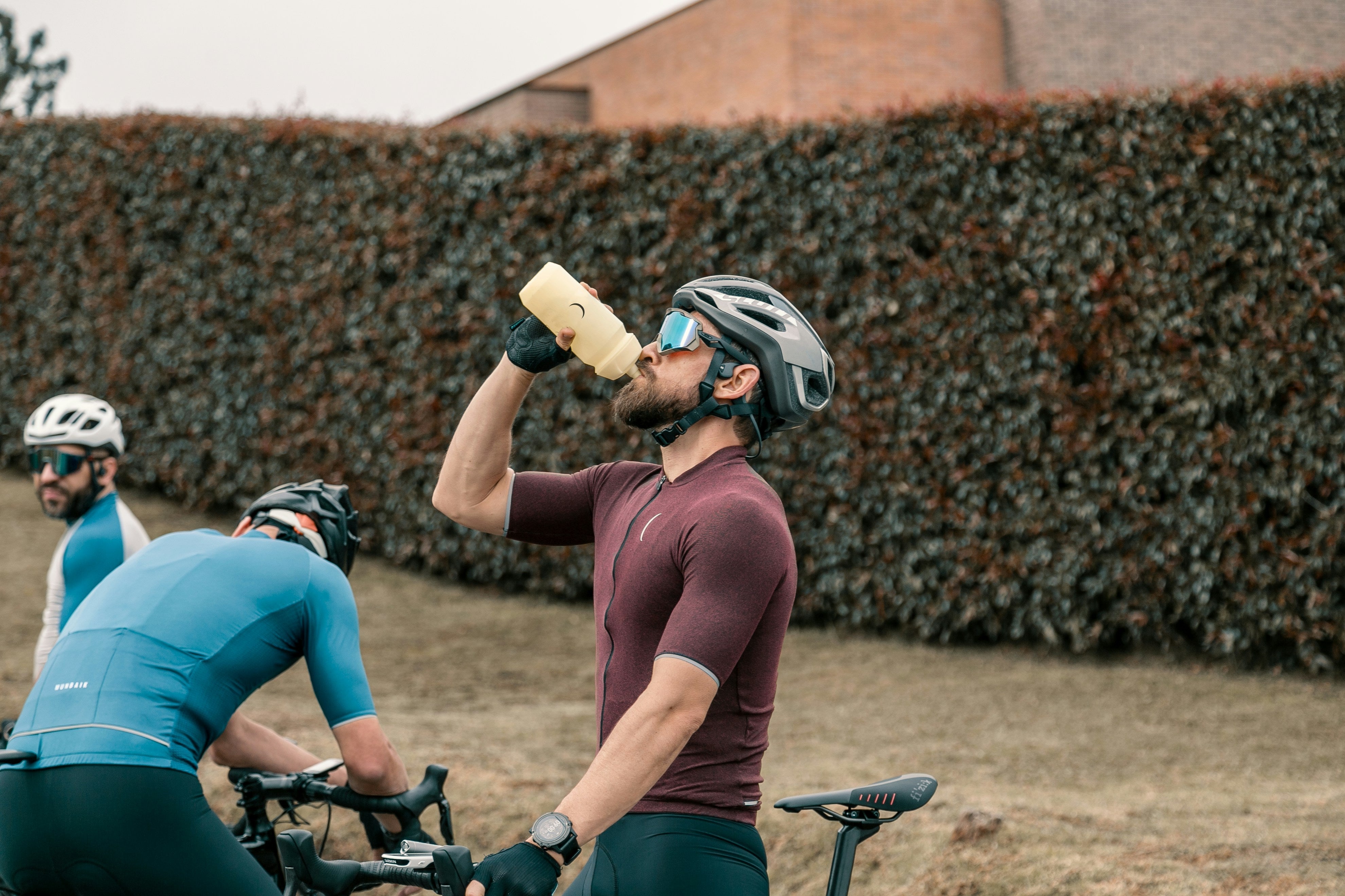 A bicyclist drinking protein and electrolyte powder mixed with water