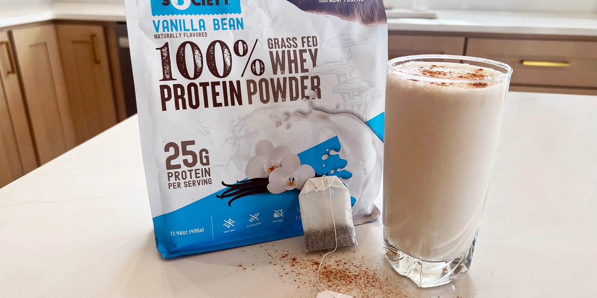 Full size package of Wild Society Grass-Fed Whey Protein Powder next to a protein shake.
