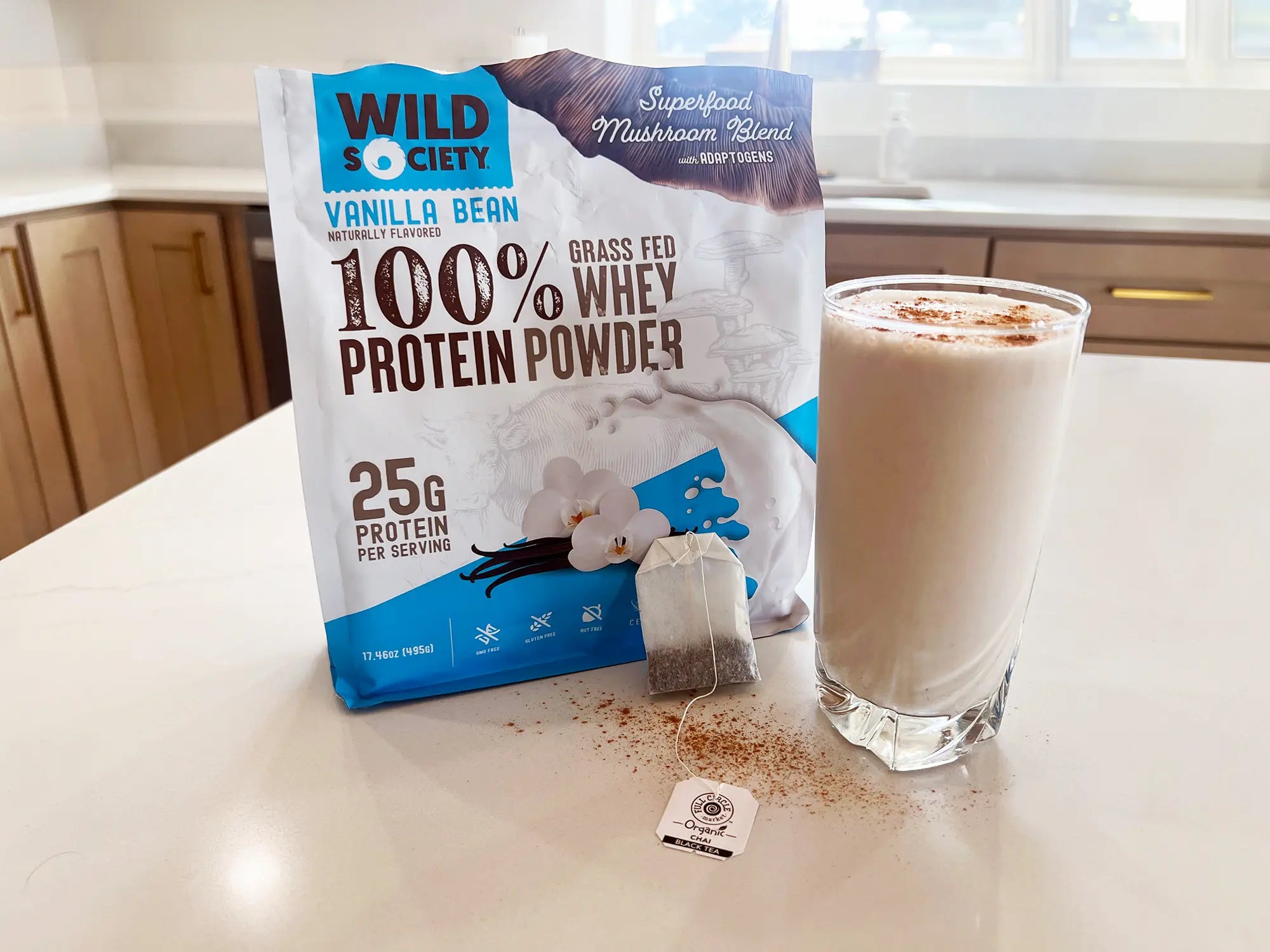 Full size package of Wild Society Grass-Fed Whey Protein Powder next to a protein shake.