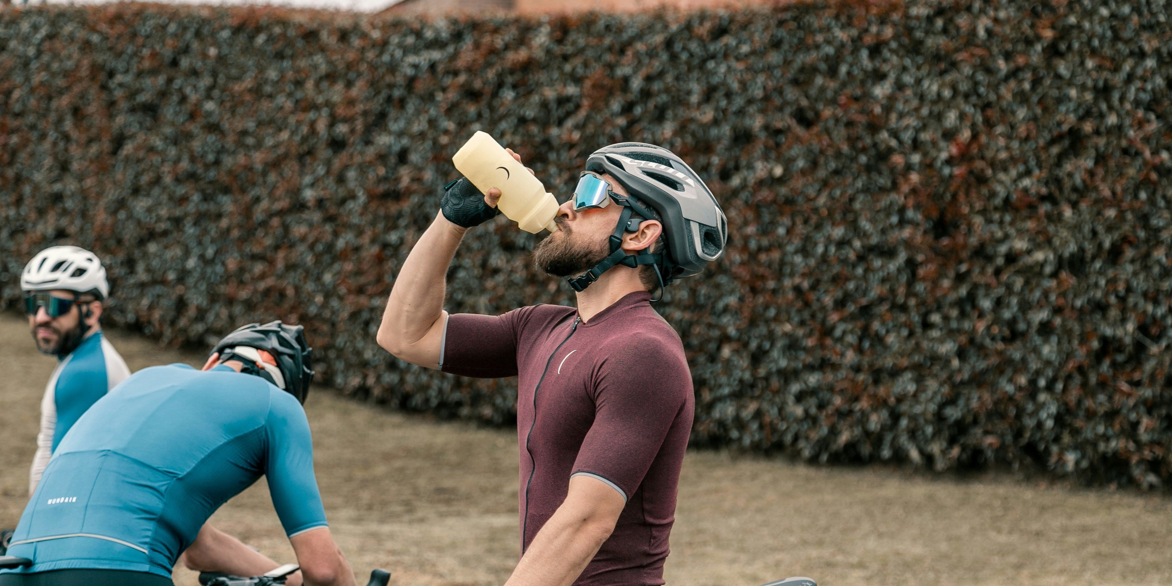 A bicyclist drinking protein and electrolyte powder mixed with water 
