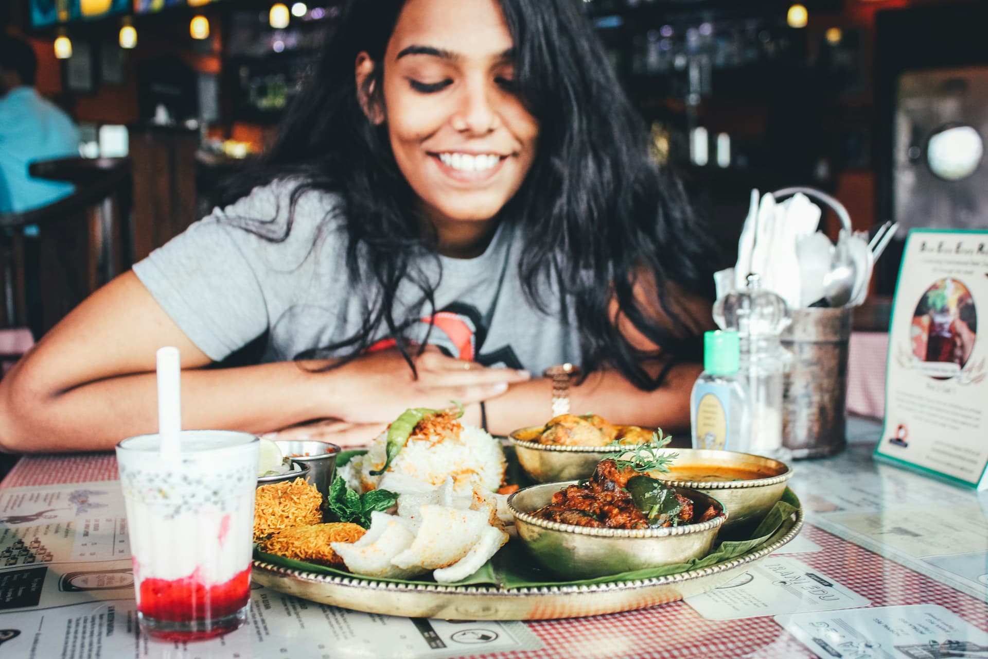 What Is a kcal vs Calorie? Woman wonders as she looks down at her meal and smiles 