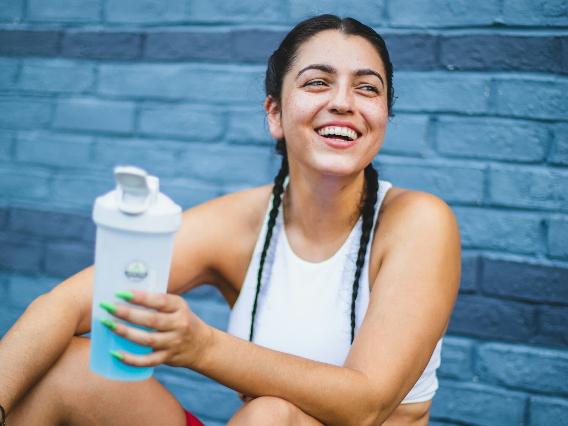 Woman looking forward to drinking Protein + Hydration while holding her shaker bottle 
