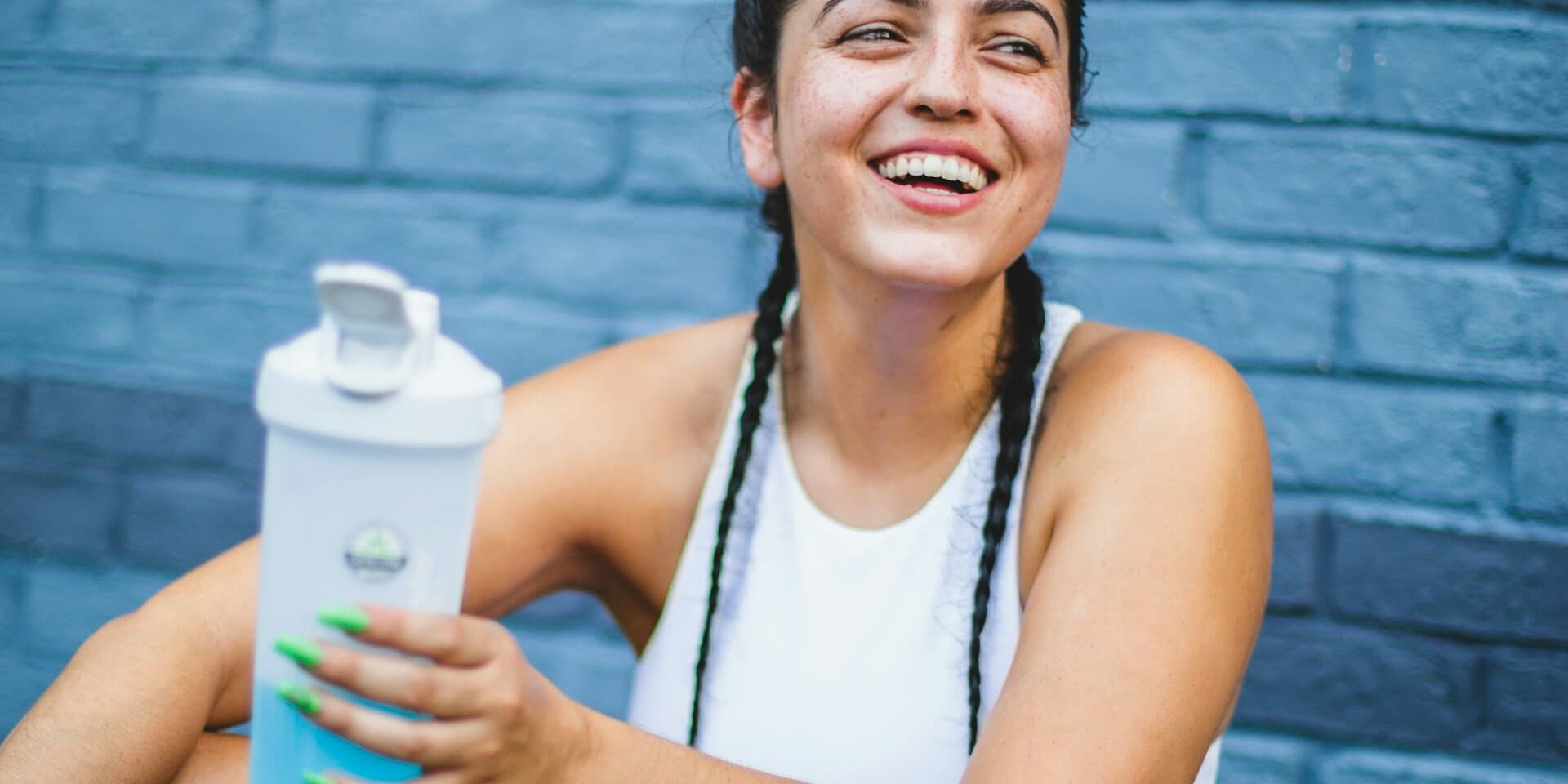 Woman looking forward to drinking Protein + Hydration while holding her shaker bottle 