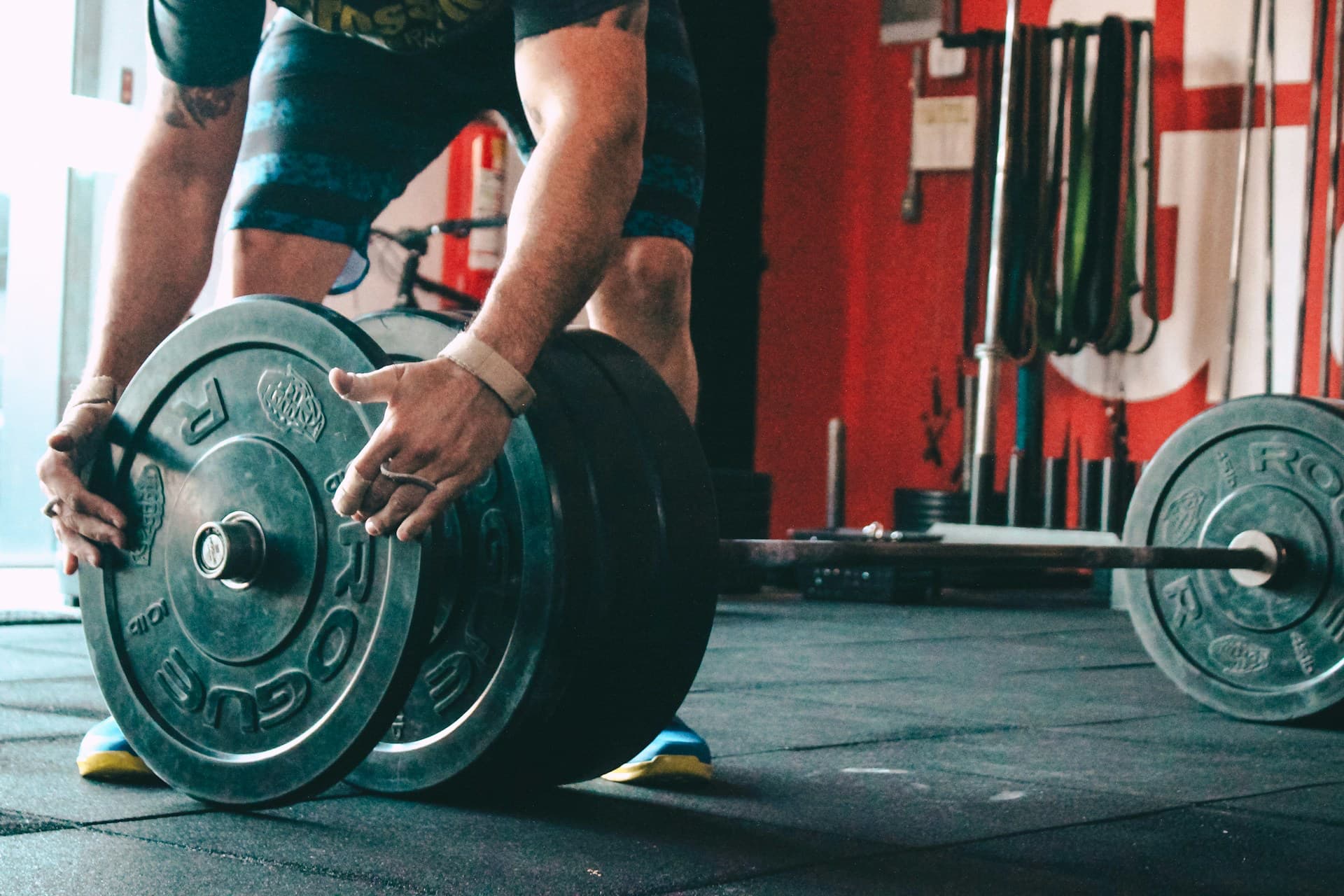 man putting plates on a barbell 