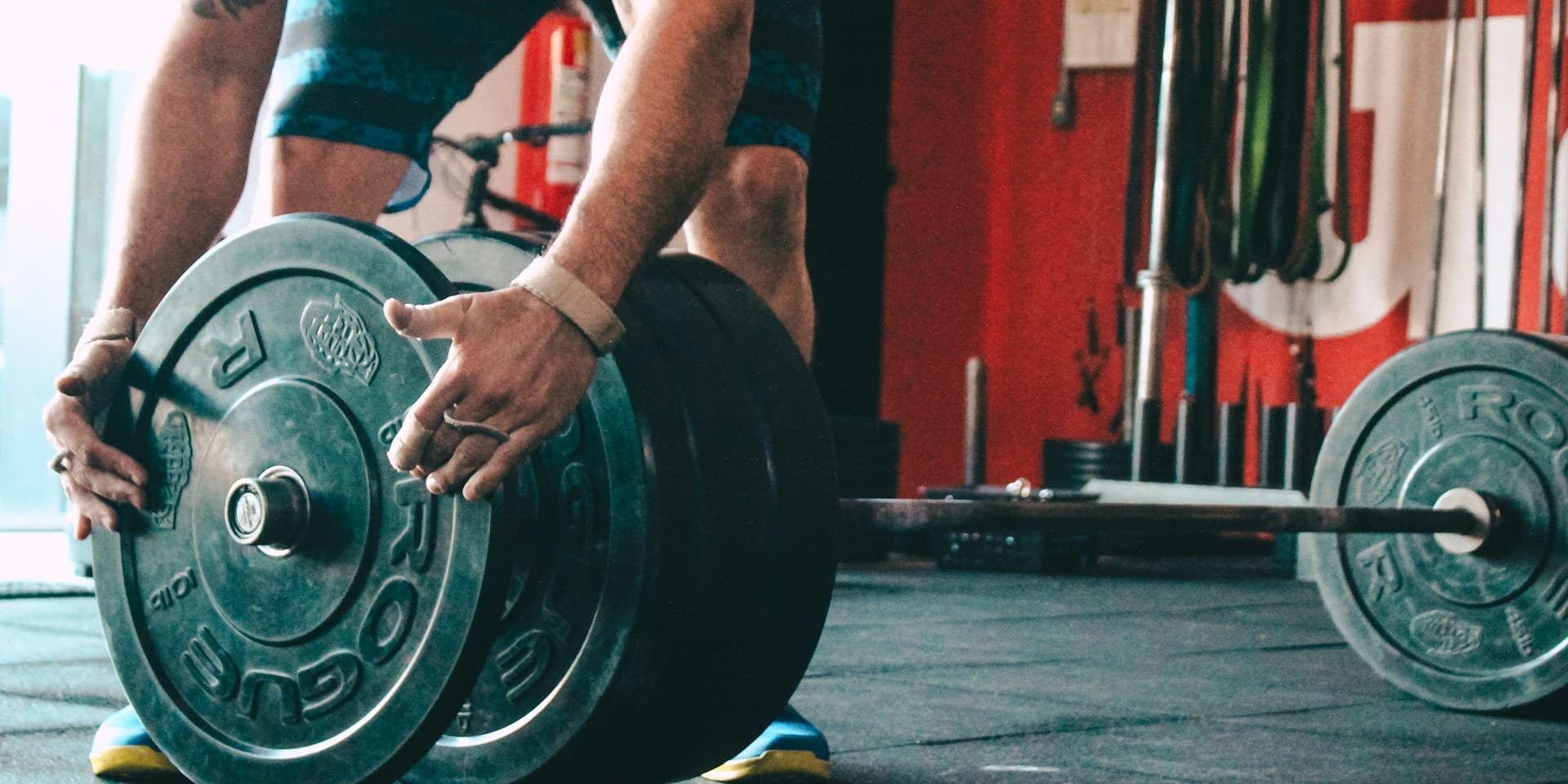 man putting plates on a barbell 