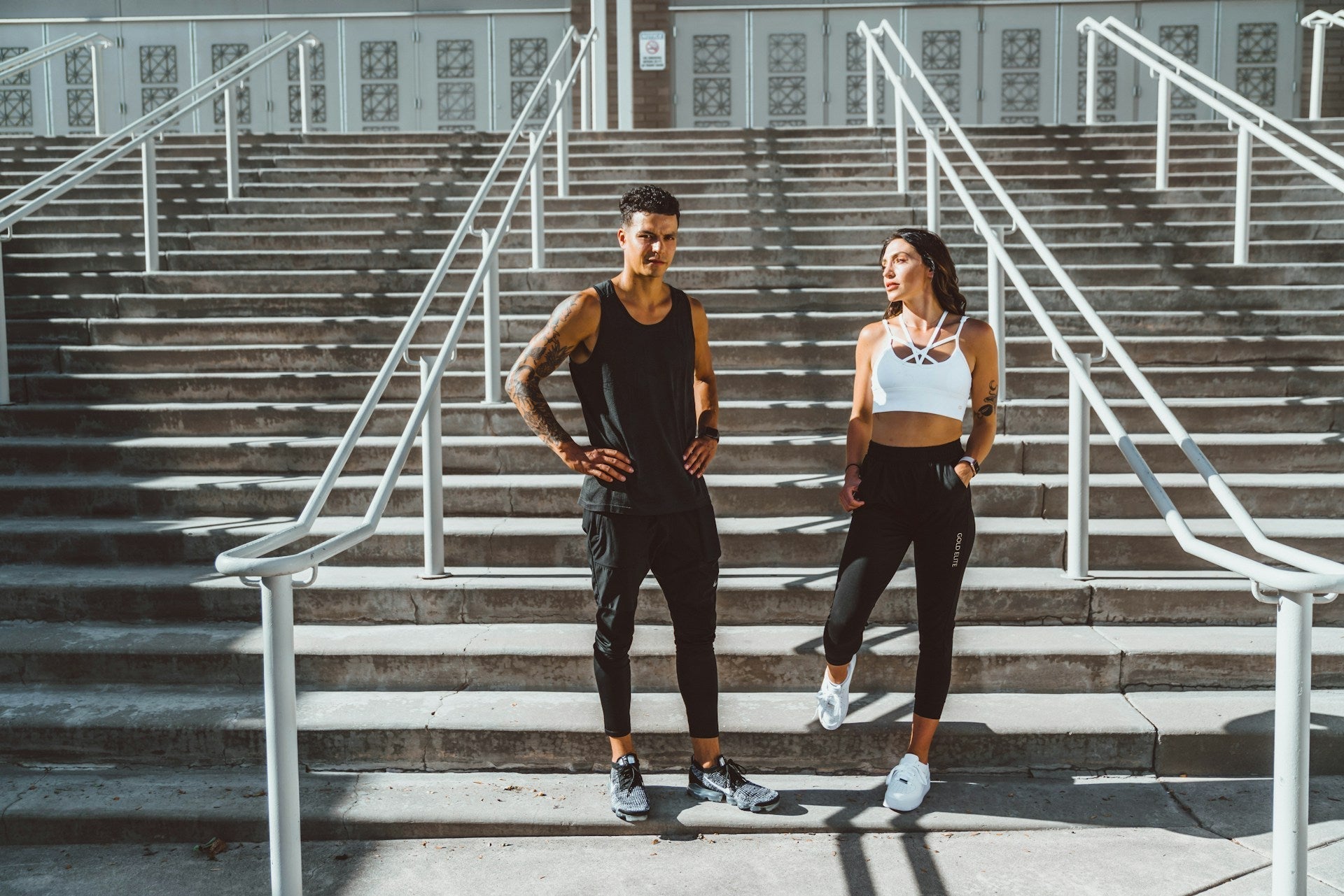 Bulk vs Cut - a man and woman workout in front of stadium steps 