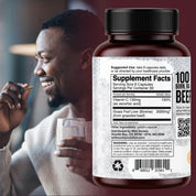 A large bottle of beef supplement capsules shown in front of a lifestyle background featuring a smiling man eating. The bottle has a black cap and a white label with black text, including '100% BORN IN BEEF' and 'Grass Fed Liver (Bovine) 3000mg'.