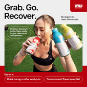 Woman holding multiple Wild Society bottles with promotional text on a grassy background
