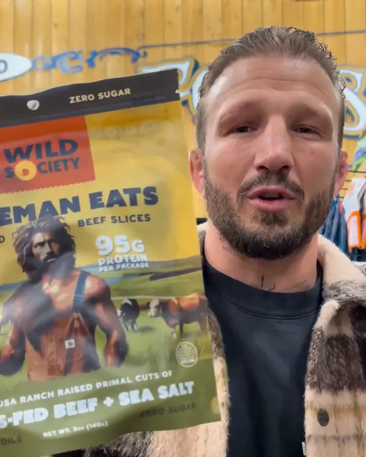 TJ Dillashaw holding a bag of Caveman Eats